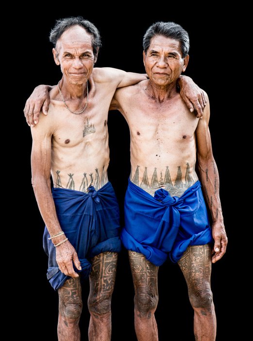 Фотография двух мужчин племени Карен с традиционными татуировками, сделанная в студии на открытом воздухе.