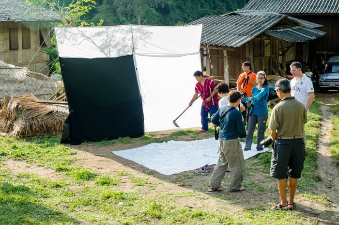 Установка студии портретной фотографии на открытом воздухе для мастер-класса в отдаленной деревне на севере Таиланда.