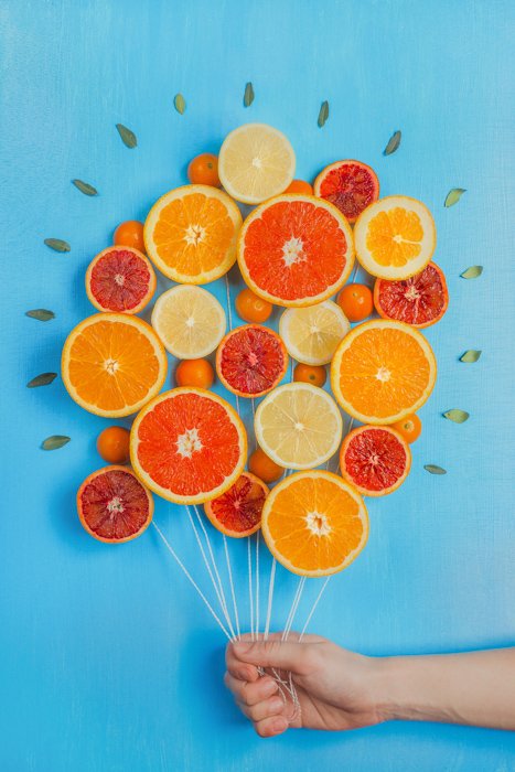Натюрморт фотографии идеи расположение апельсинов, сделанных так, чтобы выглядеть как связка воздушных шаров, на синем фоне 