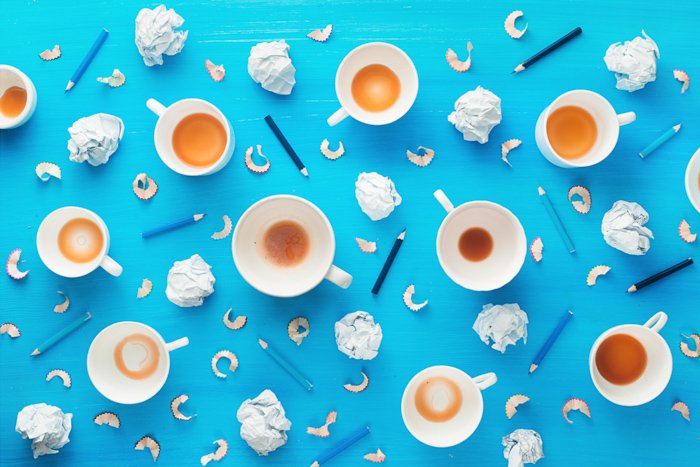 Креативные идеи фотографии натюрморта с пустыми кофейными чашками, смятыми бумажными шариками и карандашными стружками на красочном голубом фоне. Минималистская концепция вдохновения.
