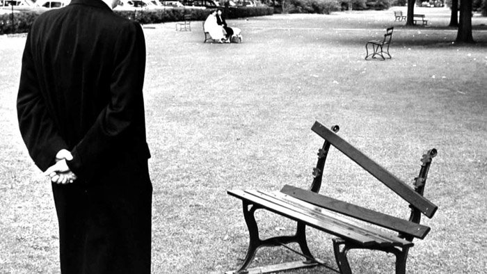 Andre Kertesz фото мужчины, стоящего перед сломанной скамейкой в парке