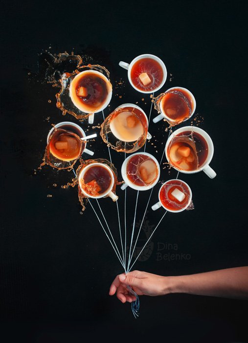 Игривый фуд-фотоснимок человека, который держит ниточки к девяти кофейным чашкам, как будто держит связку воздушных шаров