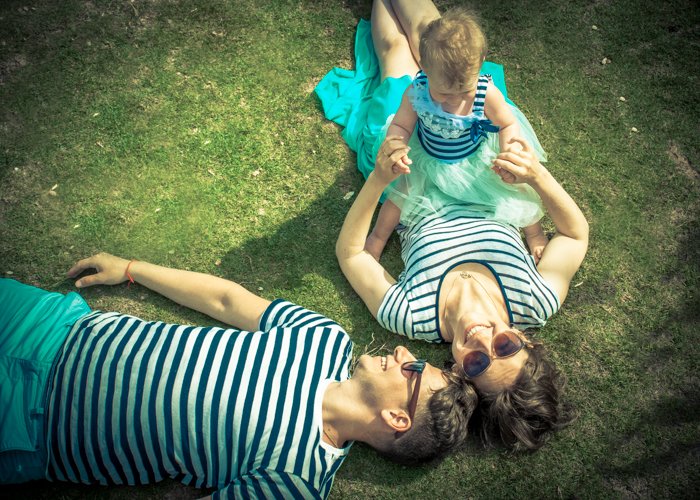 Накладной портрет женщины, держащей маленького ребенка, и мужчины, лежащего рядом с ней на траве - композиция для семейных портретов