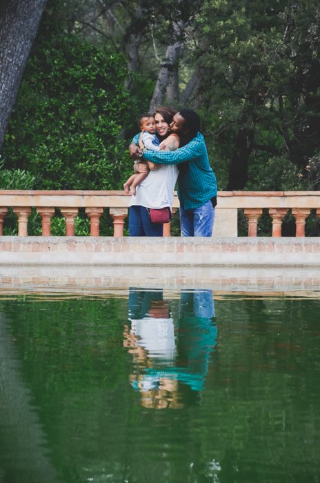 Пара с маленьким ребенком позирует перед прудом - композиция для идей семейных фотографий