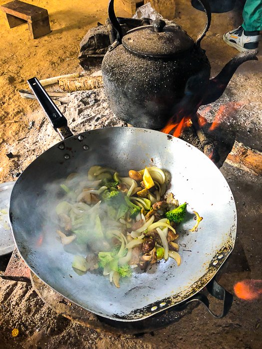 Сковорода с мясом и овощами готовится на открытом огне