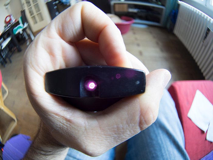 Close up of the hand holding a TV remote control using infrared light