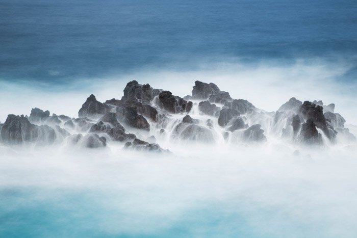 Туман над скалами в океане, снятый с помощью длинной экспозиции
