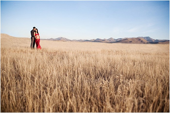Пара позирует вместе в спокойном пейзаже кукурузного поля, демонстрируя позы для фотосъемки материнства