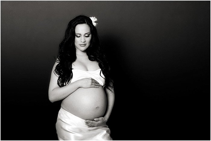Черно-белый портрет беременной женщины, держащейся за живот