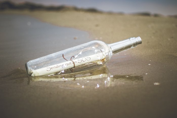 Сообщение SOS внутри бутылки на песке - классные идеи для пляжной фотографии