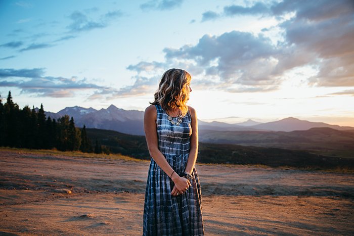 Портрет девушки, стоящей на фоне красивого пейзажа