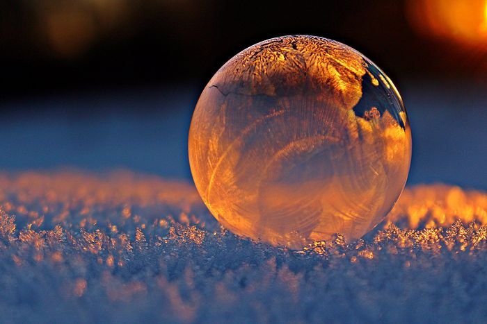 крупным планом фото мыльного пузыря, отражающего снежинки