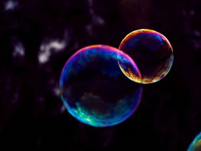 макрофотография двух разноцветных мыльных пузырей