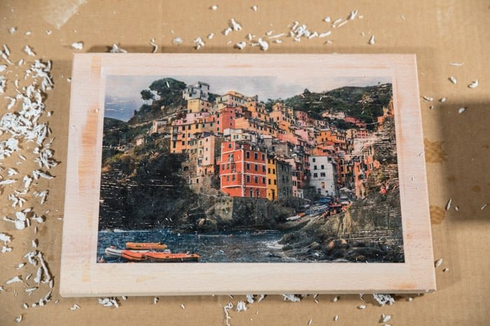 Итоговое изображение - красочная фотография прибрежного города, перенесенная на деревянную доску