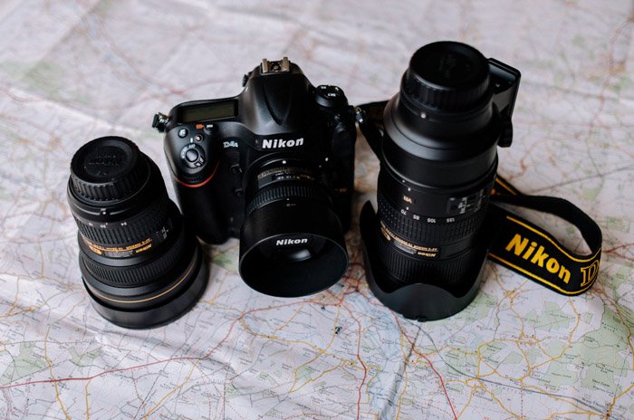 Камера Nikon dslr и два разных широкоугольных объектива лежат на карте