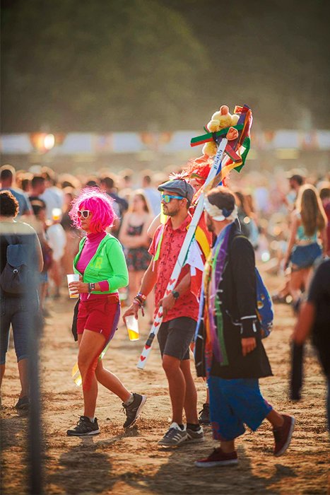 Фотография красочно одетых посетителей фестиваля на фоне хорошего боке