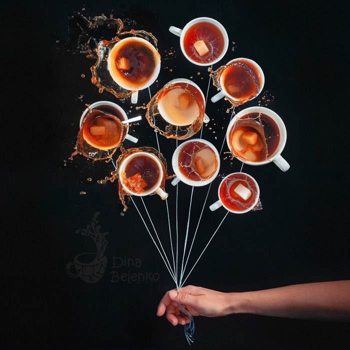 Креативный натюрморт с 10 чашками кофе, расположенными по кругу, с привязанными к ним нитками и рукой человека, держащего нитки, как будто это связка воздушных шаров