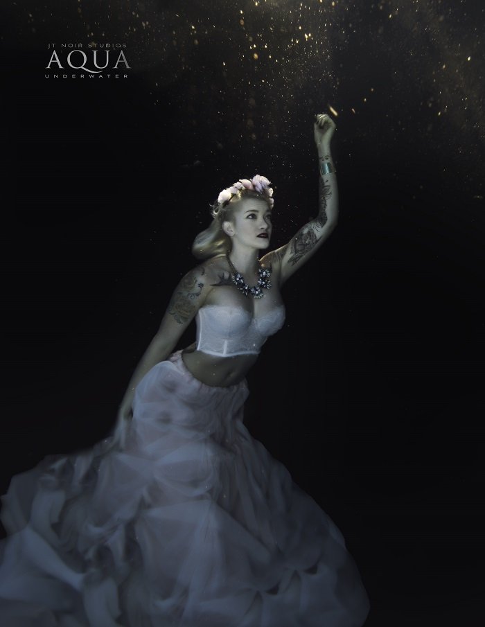 Потрясающая рекламная фотография женщины в струящемся белом платье под водой