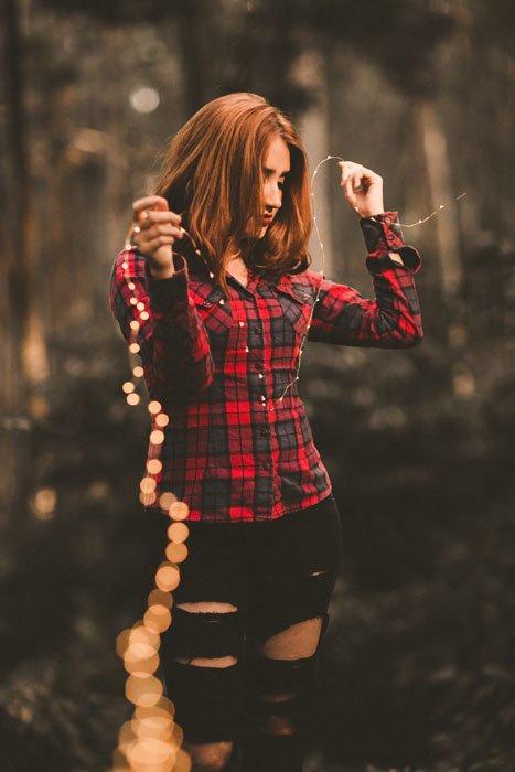 Фотография девушки, держащей нить сказочных огней