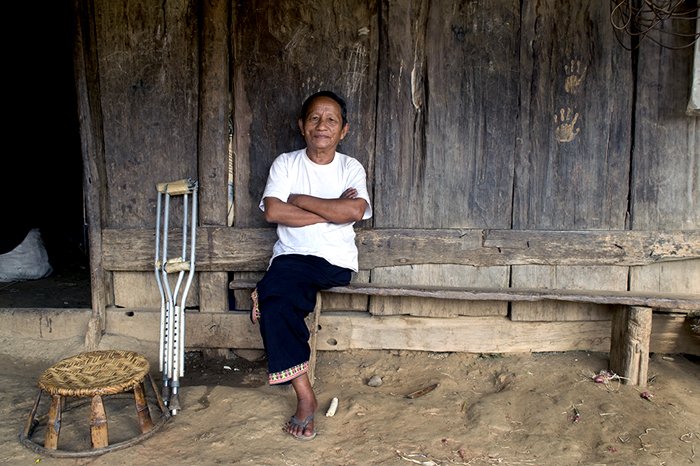 Мужчина хмонг сидит возле своего деревянного дома - советы по редакционной портретной фотографии