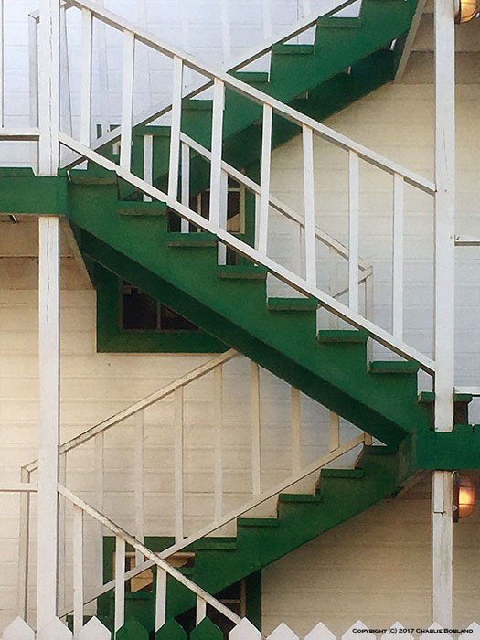Зеленая наружная лестница, диагональные линии которой создают Z-образный узор, снятый фотокамерой iPhone