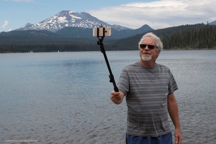Мужчина фотографирует себя с помощью палки для селфи