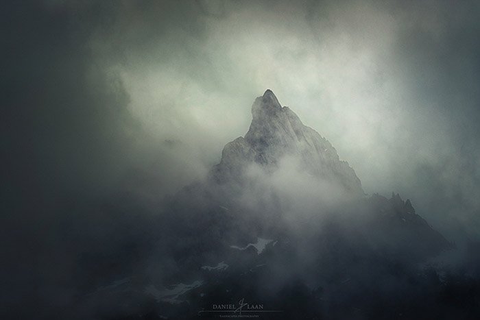 Атмосферный туманный снимок одинокой вершины в швейцарских Альпах