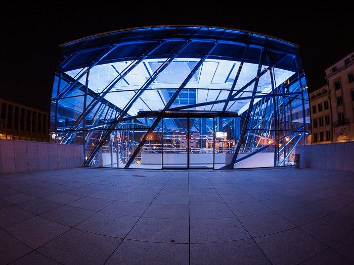 Ночная фотография геометрической структуры, освещенной изнутри электрическим синим светом. 