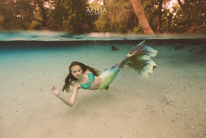 Потрясающая подводная фотография молодой девушки-русалки, плавающей под водой