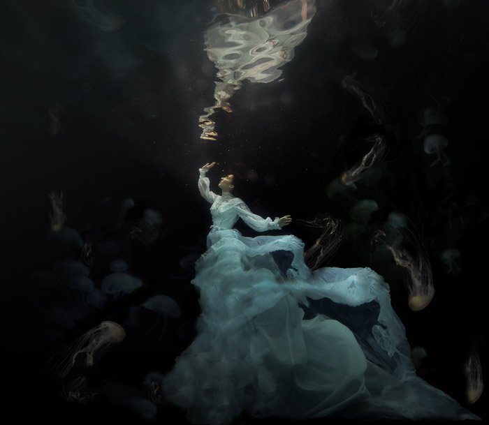 мечтательное фото женщины в струящемся белом платье под водой
