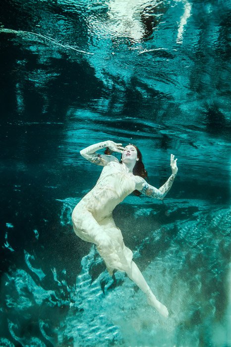 Потрясающая подводная фотография девушки, плавающей под водой