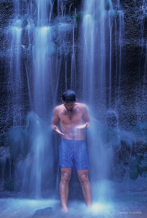 человек, стоящий в душе водопада