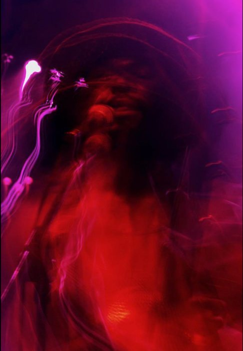Размытая фотография с красными, фиолетовыми, розовыми световыми следами от намеренного сотрясения камеры