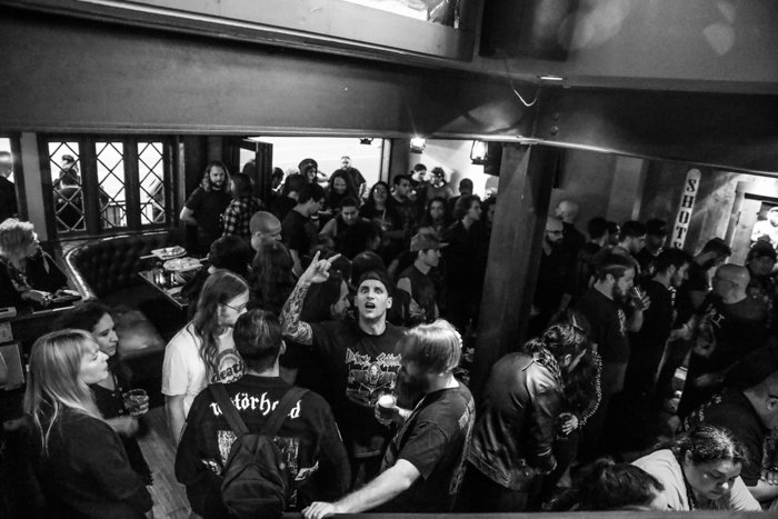Черно-белый снимок толпы в интерьере бара или концертной площадки