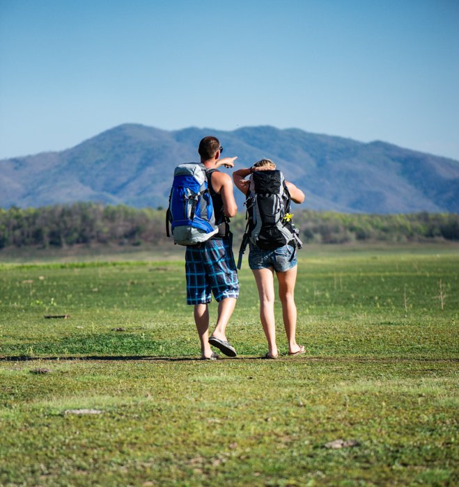 A Young couple walking together in the empty field using central composition 