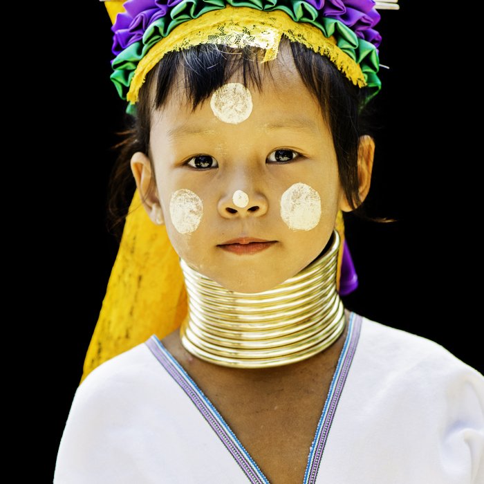 Портрет молодой тайской девушки в традиционном костюме с использованием центральной композиции на черном фоне