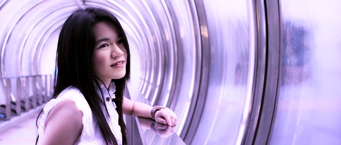 Кинематографический фотопортрет женской модели, стоящей в фиолетовом тоннеле