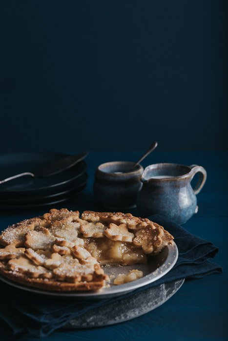 яблочный пирог с керамикой на деревянном столе