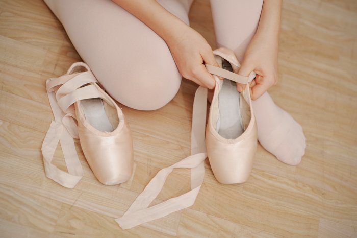 close up of girl putting on her ballet shoes - photo props