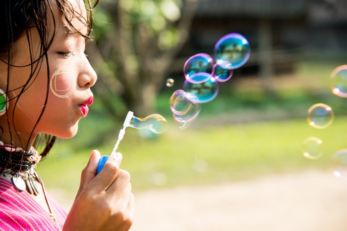 close up portrait of little girl blowing bubbles - portrait photography props
