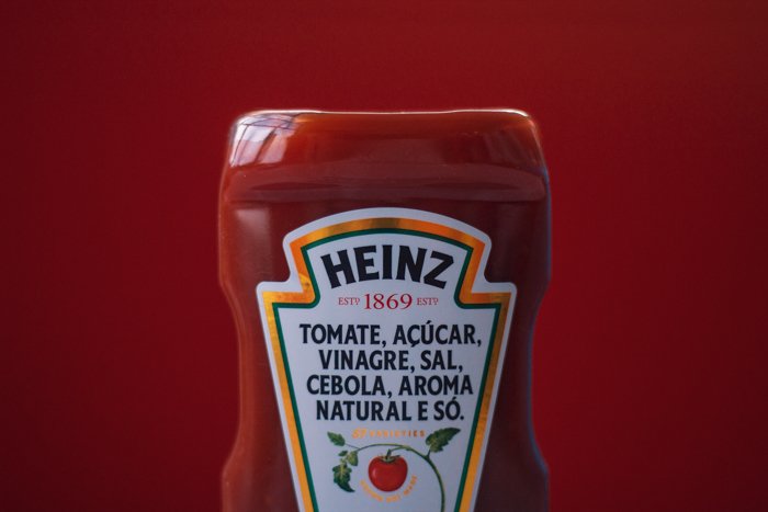крупный план половины бутылки heinz ketchuo на подходящем темно-красном фоне