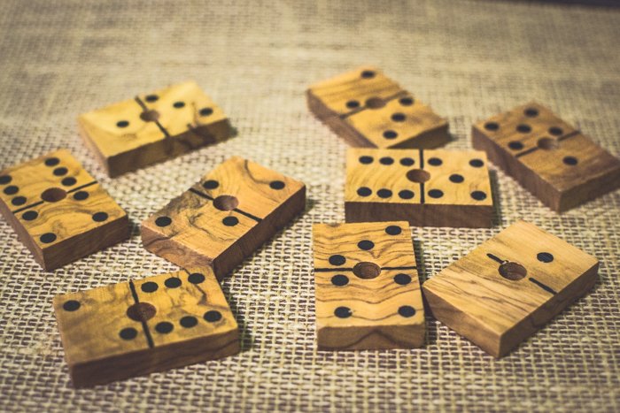 close up of nine wood domino tiles on brown table