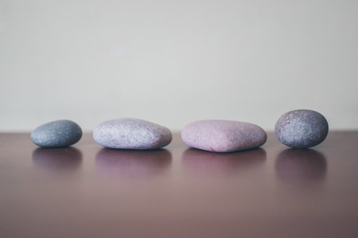 четыре серых камня, выложенных на деревянной поверхности