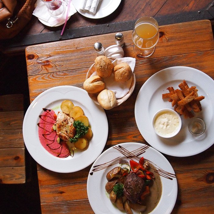 Съемка еды с верхней точки на фоне аппетитно выглядящего обеда, поданного на деревенском деревянном столе
