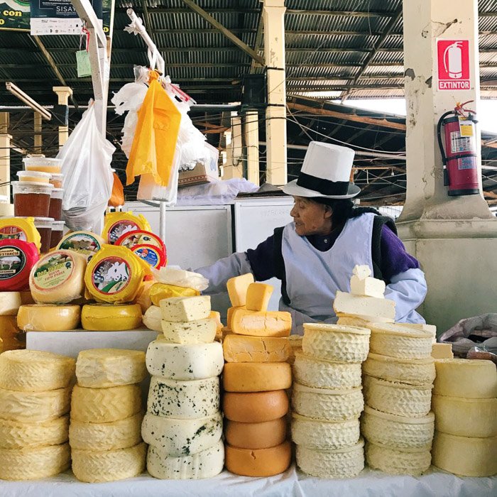 мужчина на рынке продает целые кругляши сыра - стили фотографии для смартфона