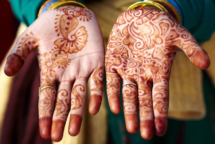 close up of hands, palms up, with henna design on them