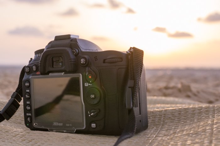 Фотокамера DSLR, лежащая на ткани на пляже
