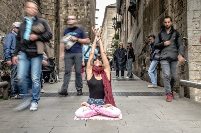 Девушка в позе йоги посреди оживленной улицы - основы DSLR для начинающих фотографов