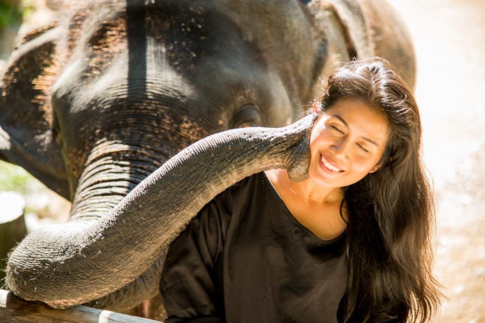 Портретная фотография девушки рядом со слоном