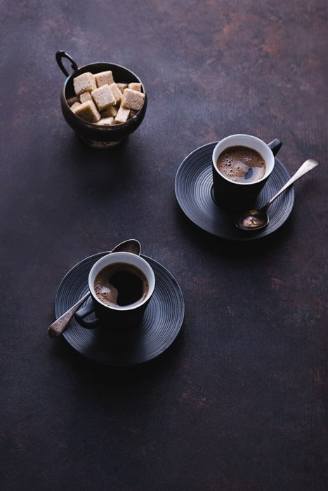 Мрачный и атмосферный натюрморт с двумя кофейными чашками и сахаром